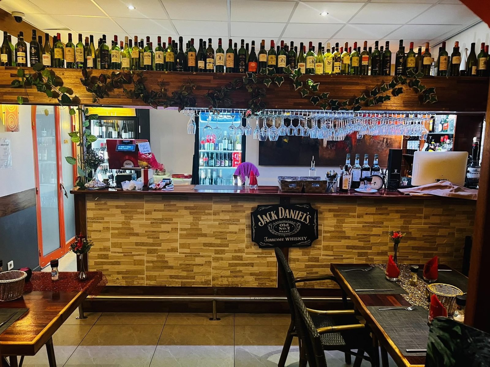 La salle et le bar du Manava Café, étagère de bouteilles et comptoir en pierre